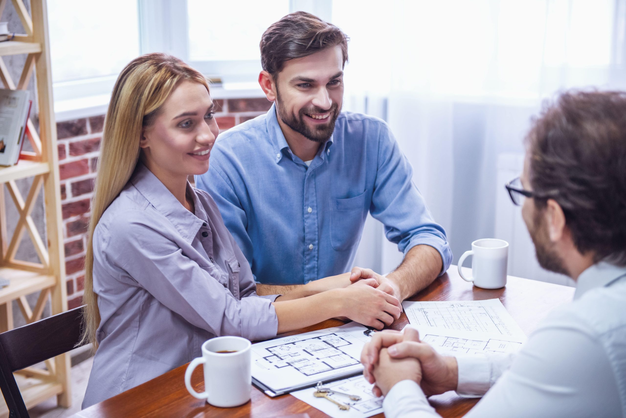 pareja recibiendo asesoramiento de una inmobiliaria en Málaga para comprar vivienda